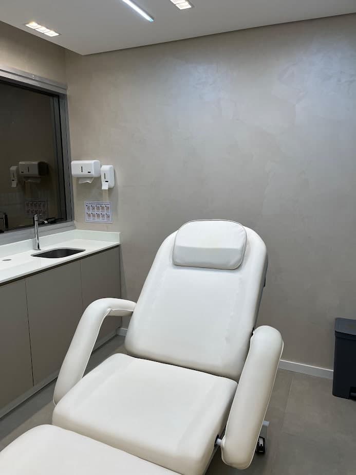 Sala de procedimentos, com maca reclinável e bancada