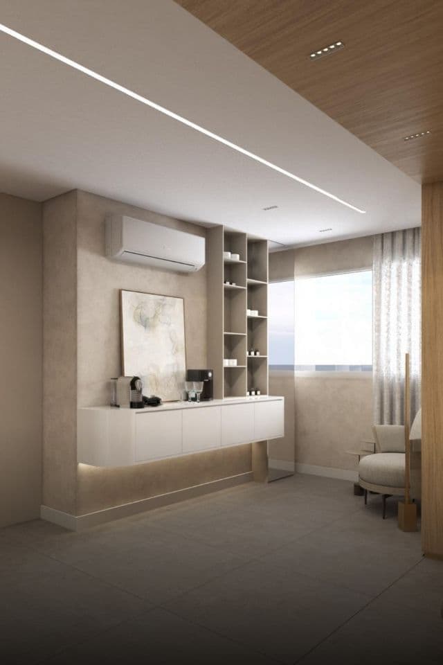 Sala de espera da clínica, em tons neutros, com poltrona junto à janela